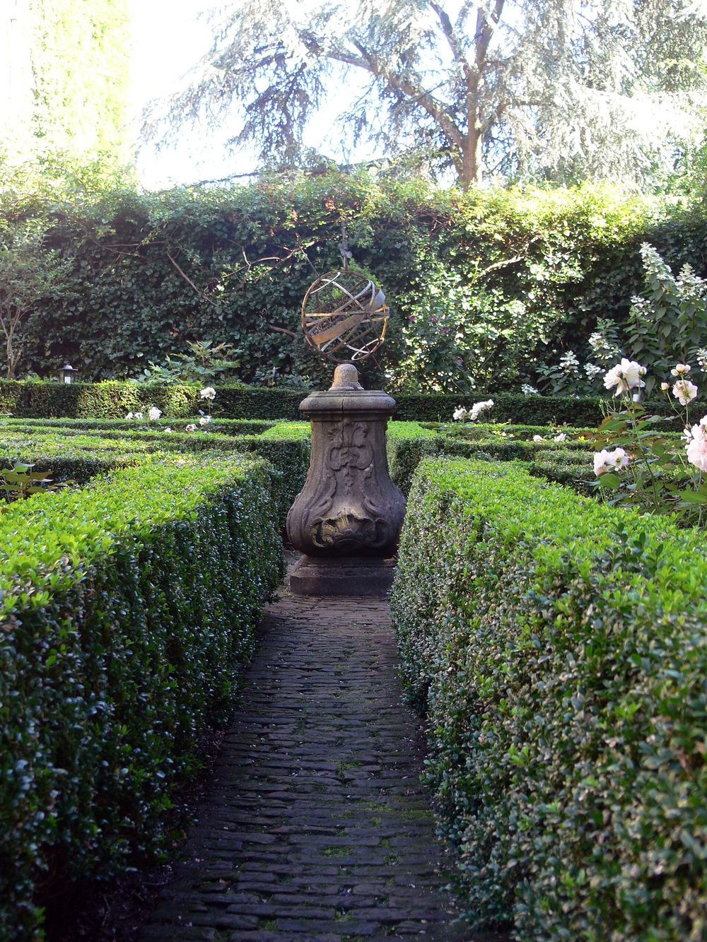 Setos de boj y un reloj de sol en el jardín del Museo Van Loon