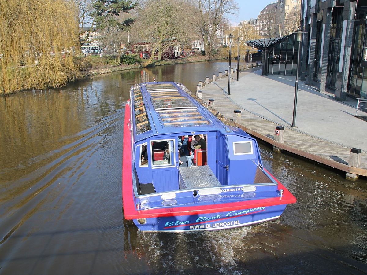 Un barco de crucero por los canales en un canal de Ámsterdam